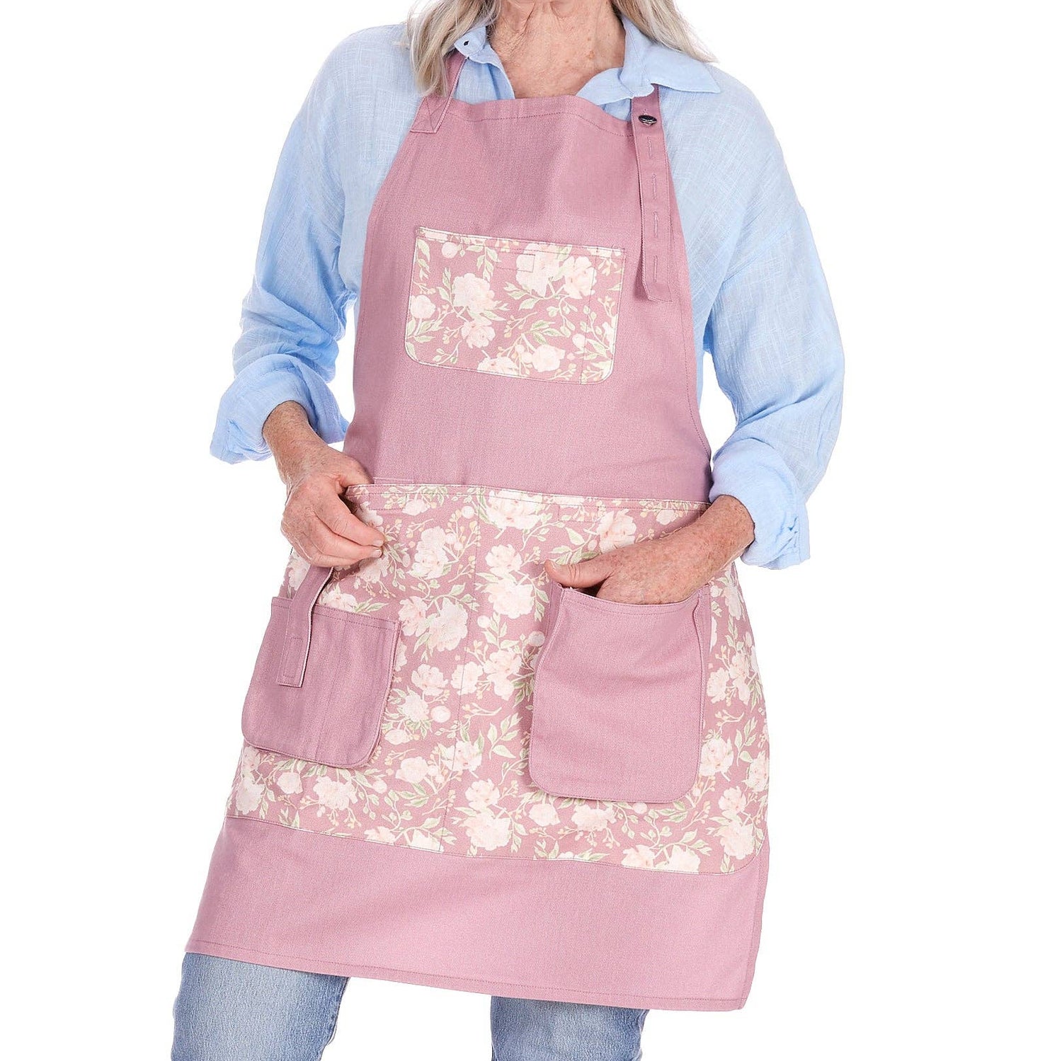 Woman wearing a pink gardening apron with floral patterns on a white background