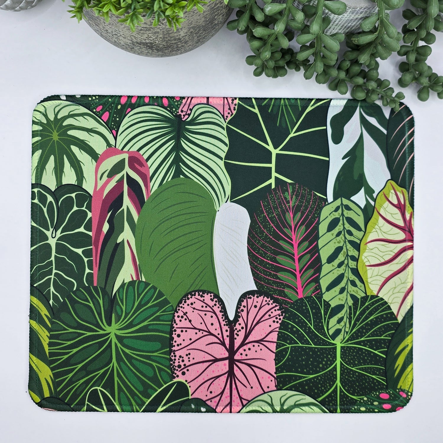Mouse pad with tropical Aroid leaf design on a white surface