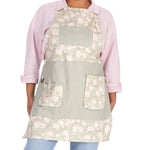 Person wearing a floral gardening apron on a white background