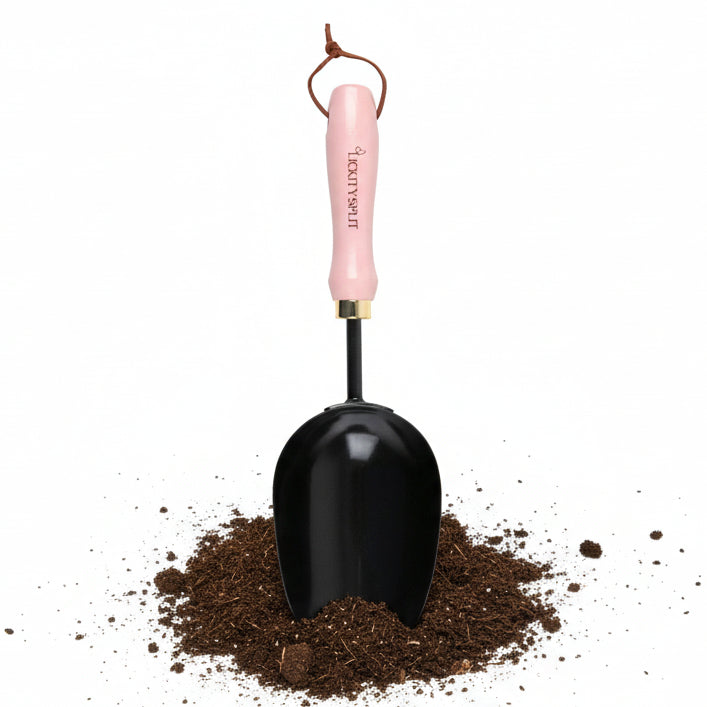 Black garden shovel with pink handle on a white background