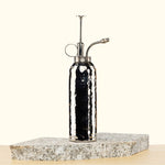 Silver Metal Plant mister on a stone surface with a white background