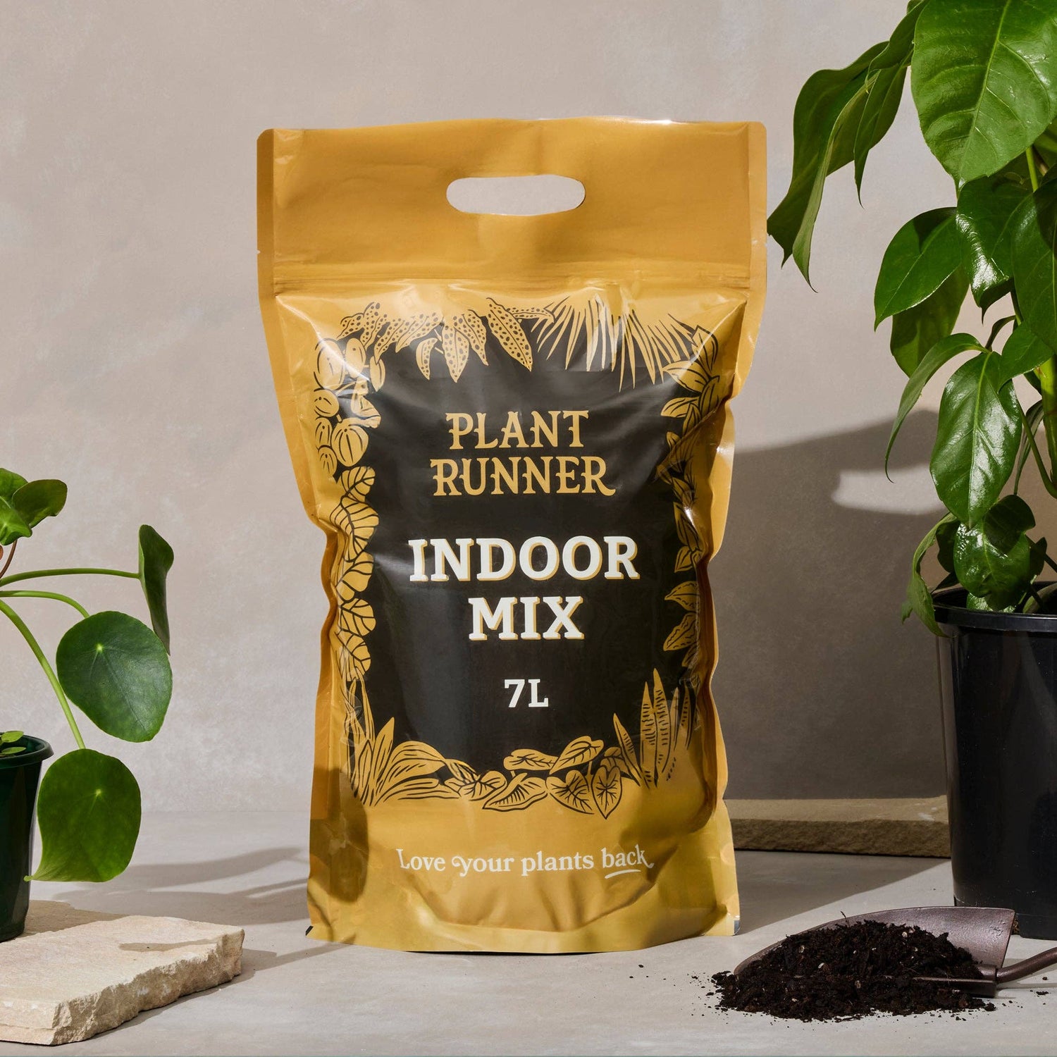 Bag of Plant Runner Indoor Mix on a table with plants and soil in the background