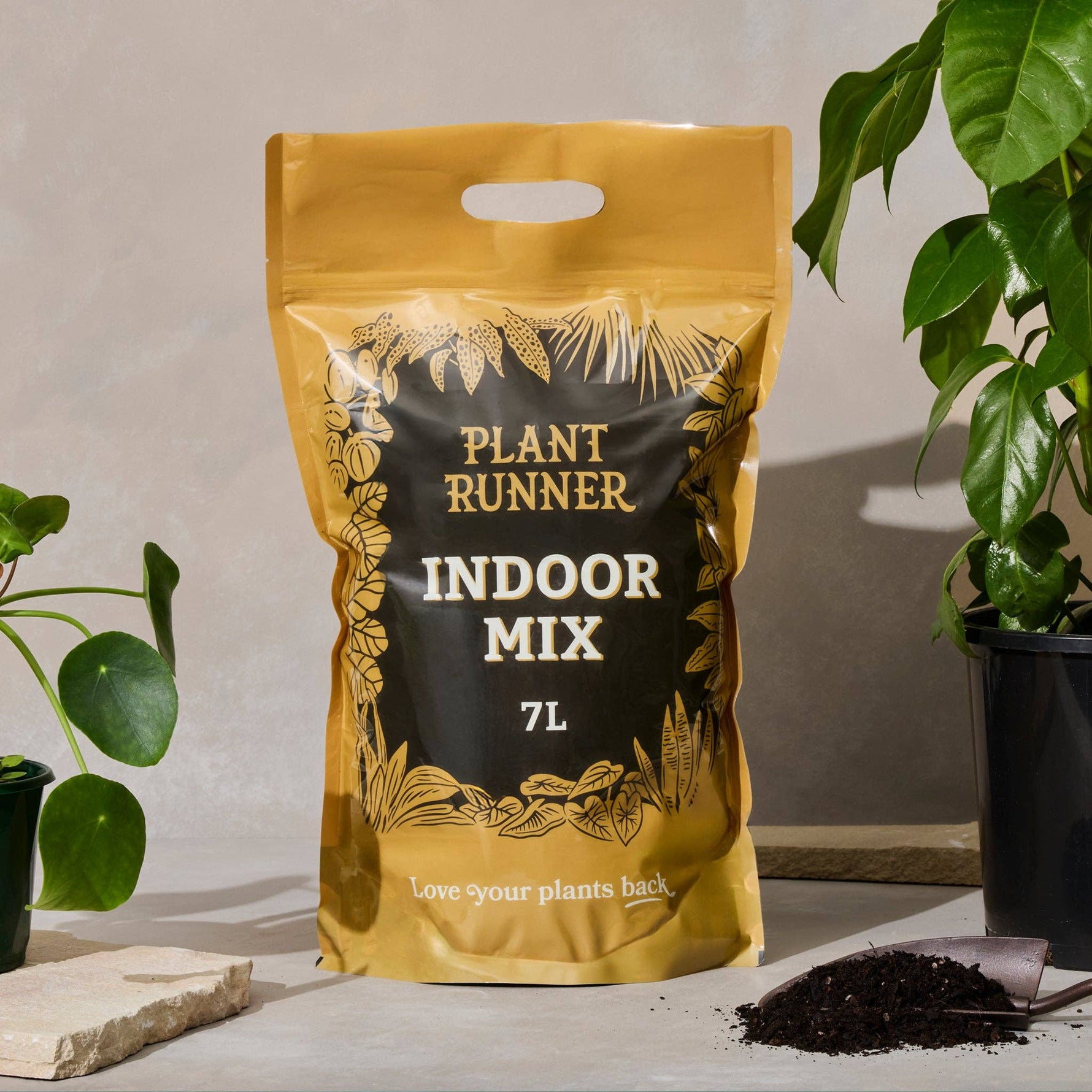 Bag of Plant Runner Indoor Mix on a table with plants and soil in the background